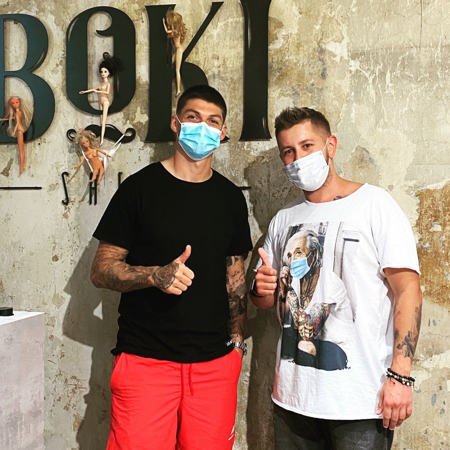 Steven Zuber gemeinsam mit Boki vor der Boki-Wand im Salon