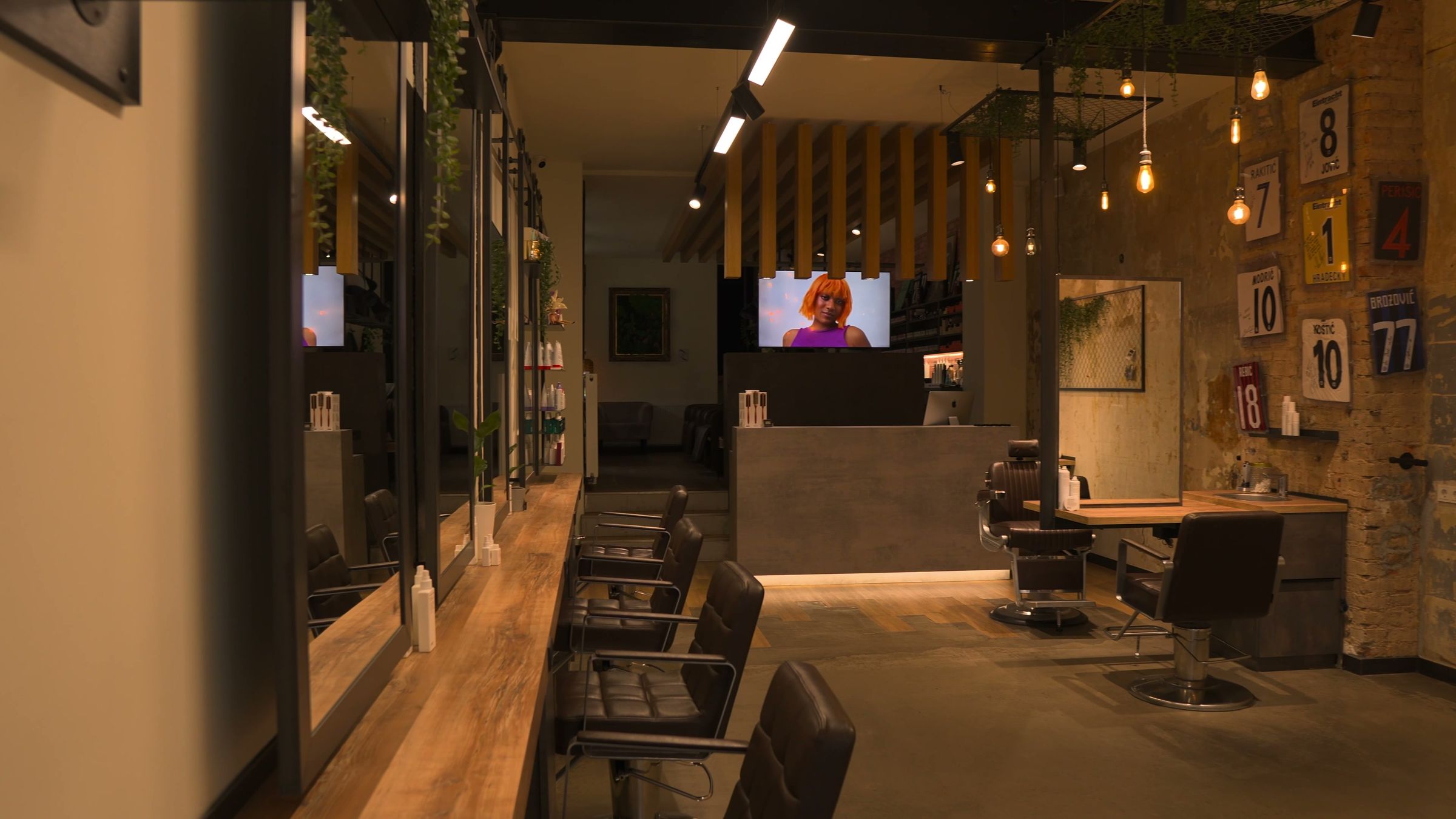 Blick in das Loft von Boki Salon: Spiegelreihe, Barberstühle und Glühbirnen an der Betondecke